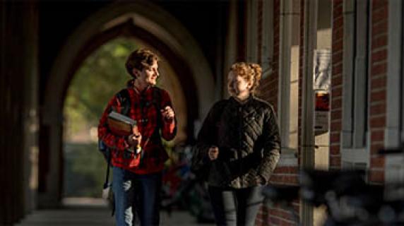 two students walking in the loggia