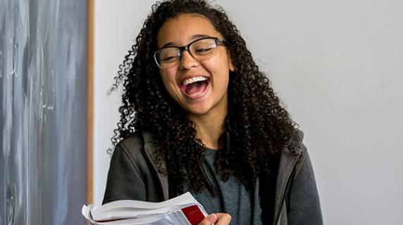 student laughs at blackboard