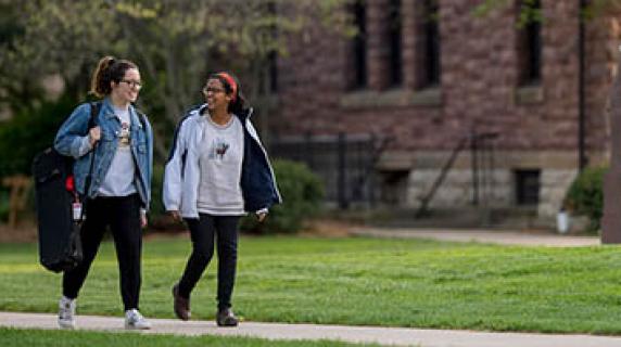 two students walk near Goodnow Hall