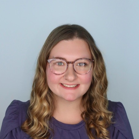 A woman smiles for a headshot