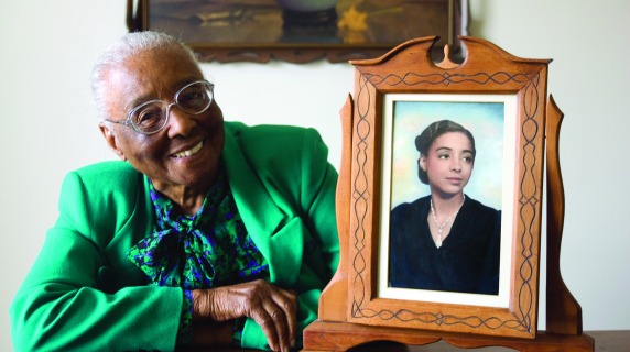 Edith Renfrow Smith poses with a framed photo of her younger self.