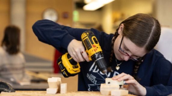 Student drilling into a block of wood