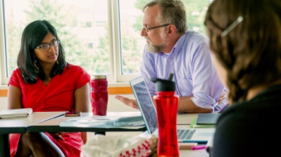 Faculty member talking with students.