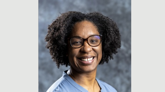 A woman smiles for a headshot