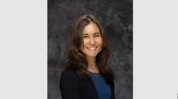 A woman smiles for a headshot