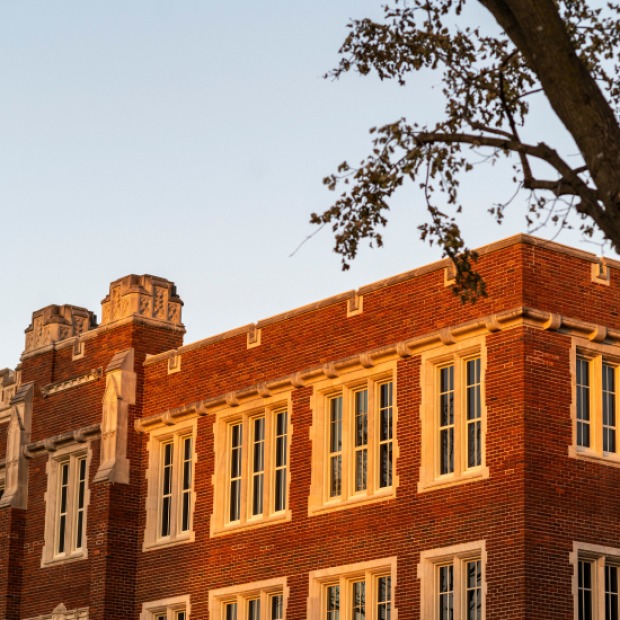 A close up of a brick building on campus at sunset.