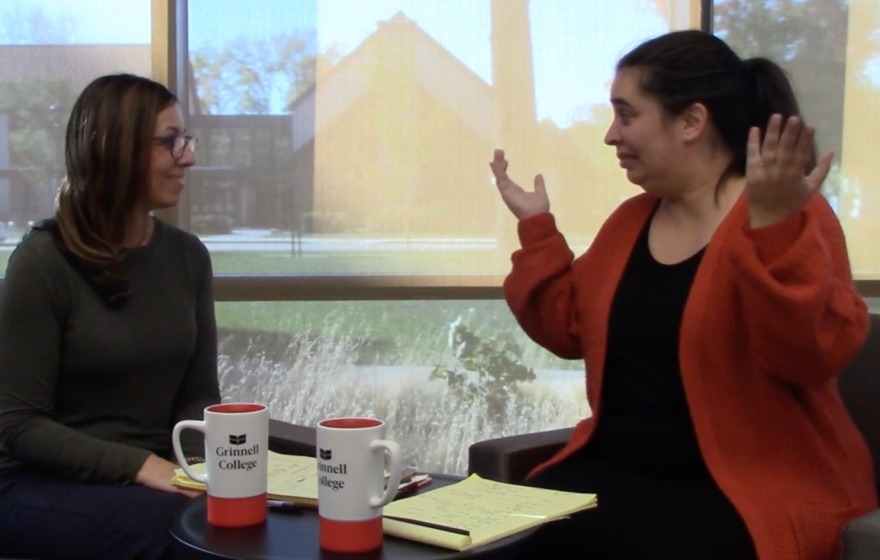 Two women talk animatedly over coffee