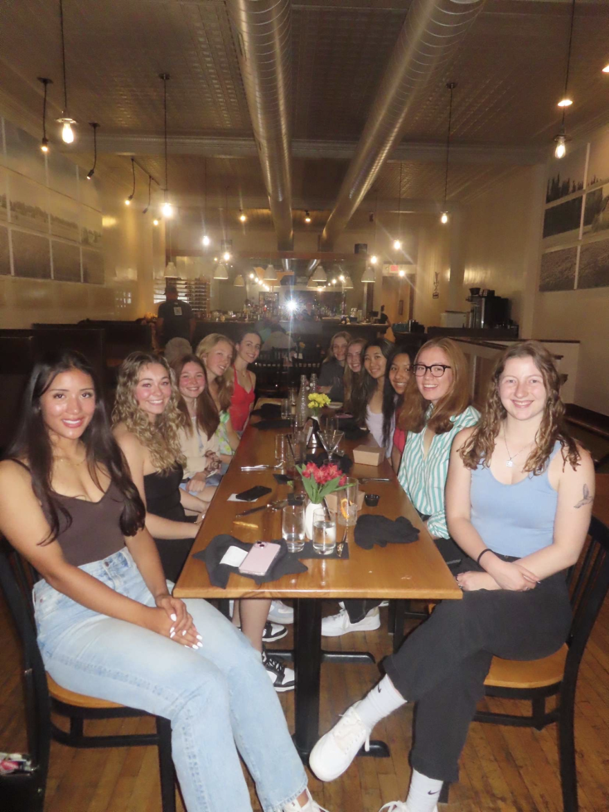 A group of young women sits at a table in a restaurant