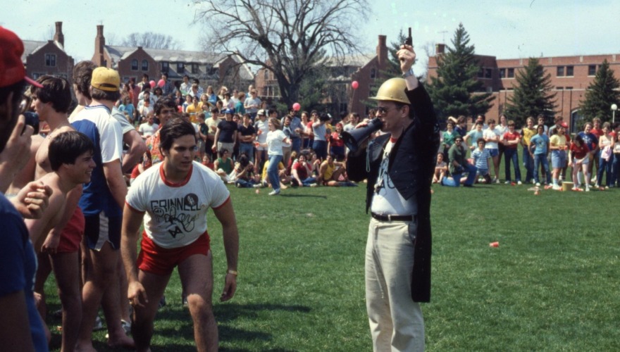 A man in a tailcoat and gold-painted helmet begins a race on Central Campus.