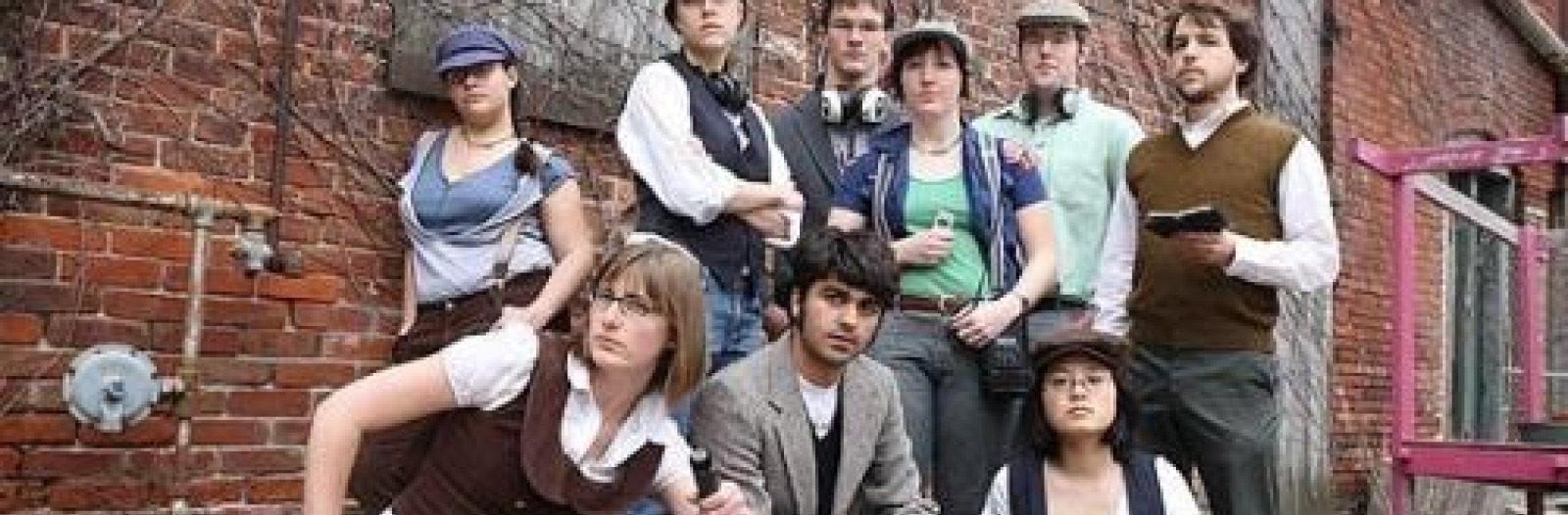 The Listen Hear staff, dressed as old-timey newsboys, pose with audio equipment.