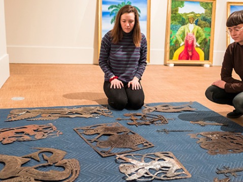 Students lay out art pieces for exhibit