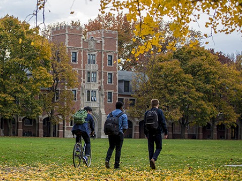 3 students cross Mac field