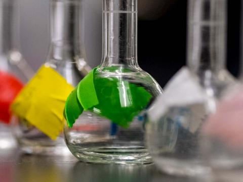 science beakers in a row with different colored tape