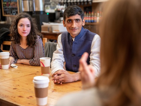 man at coffee shop with students