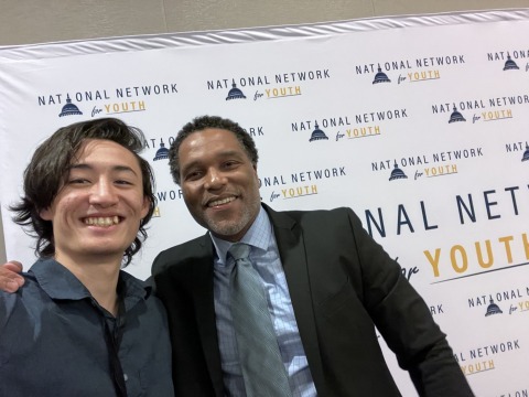 Keanu with Dr. Hall in front of NN4Y summit banner.