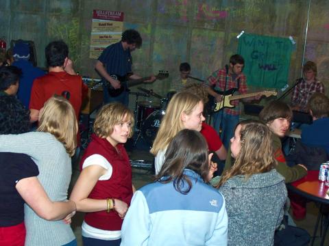 Students happily converse as they listen to the band Millard Fillmore in the Pub