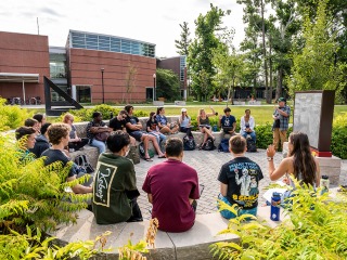 Students have class outdoors near blackboard outside HSSC