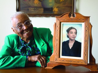 Edith Renfrow Smith poses with a framed photo of her younger self.
