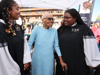 Renfrow Smith holds hands and talks to two young Black singers from the choir.