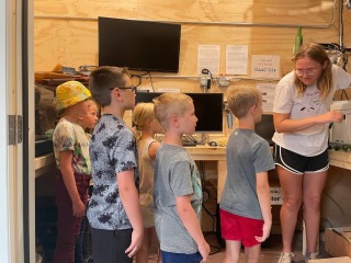 kids standing and learning looking at teacher