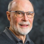 photo of Kent McClelland in a blue vest with blue background