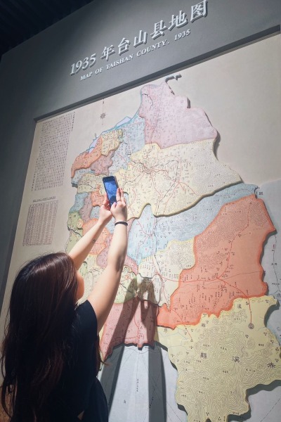 A young woman looks at a map of China.